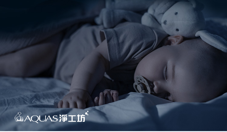 安靜的嬰兒在床上安然入睡，身邊還有絨毛玩具。